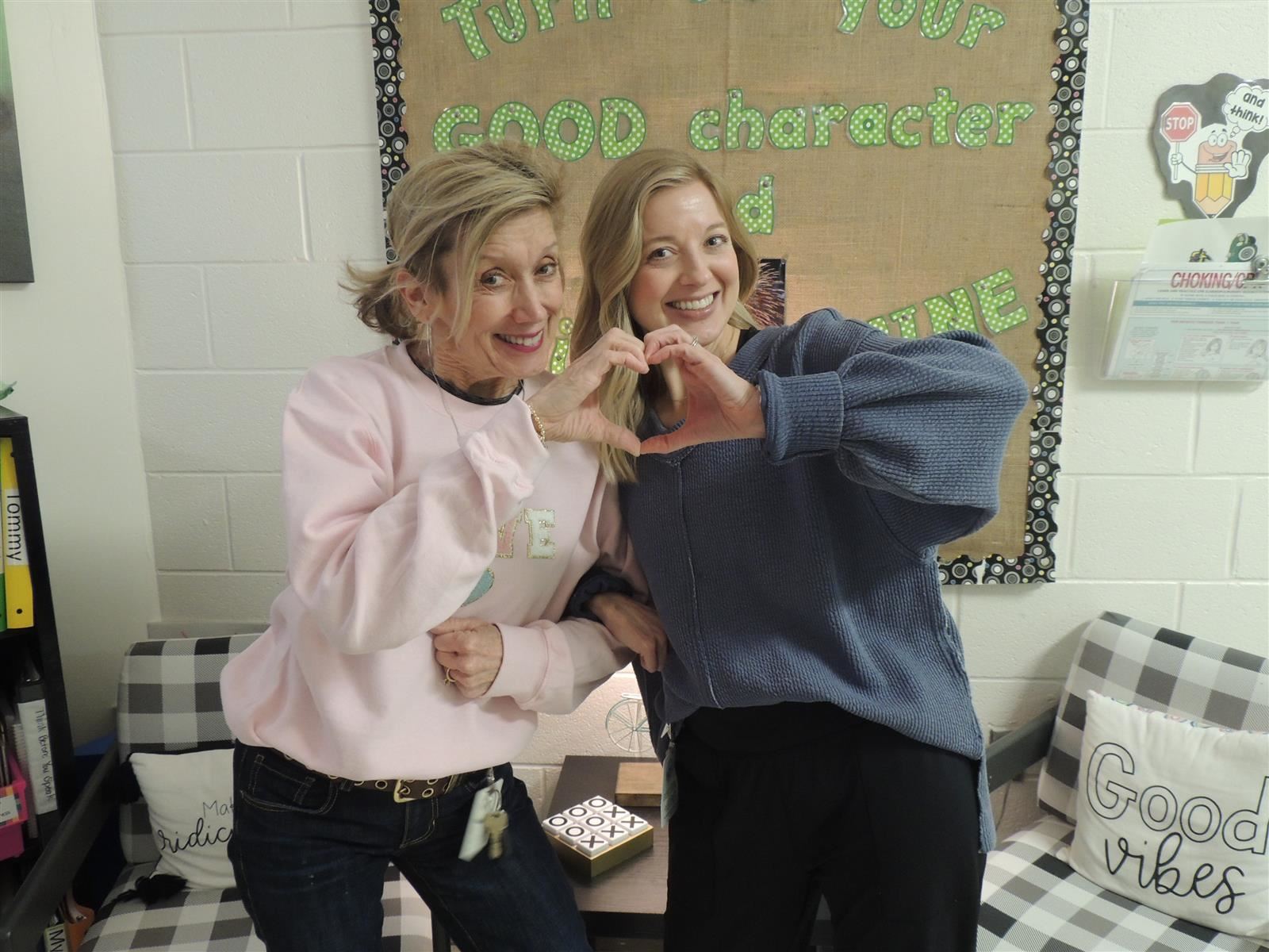 Two school counselors making a heart with their hands